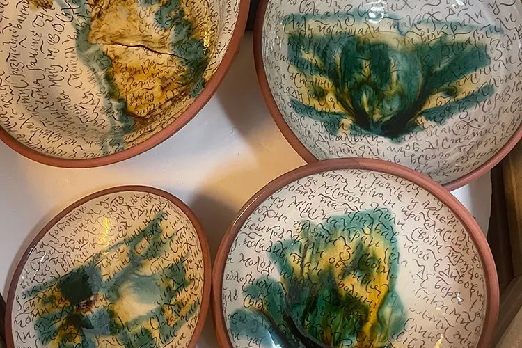 Fired plates with green and ochre glazes over a hand-drawn pattern