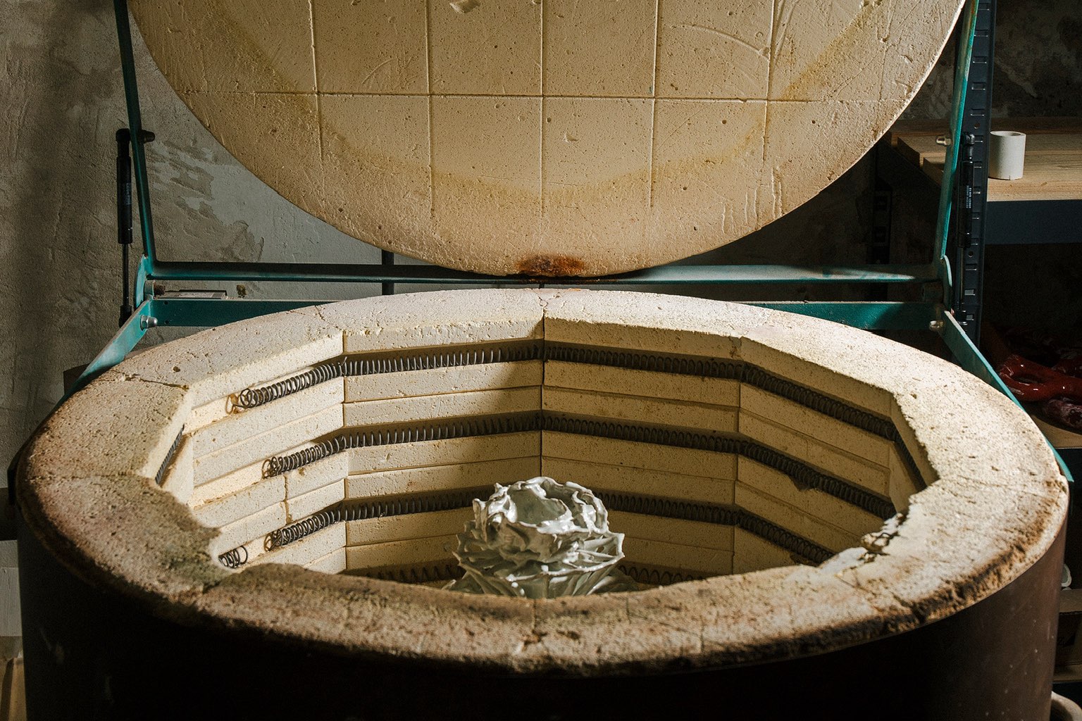An open electric kiln, the firebrick lining and a single piece inside